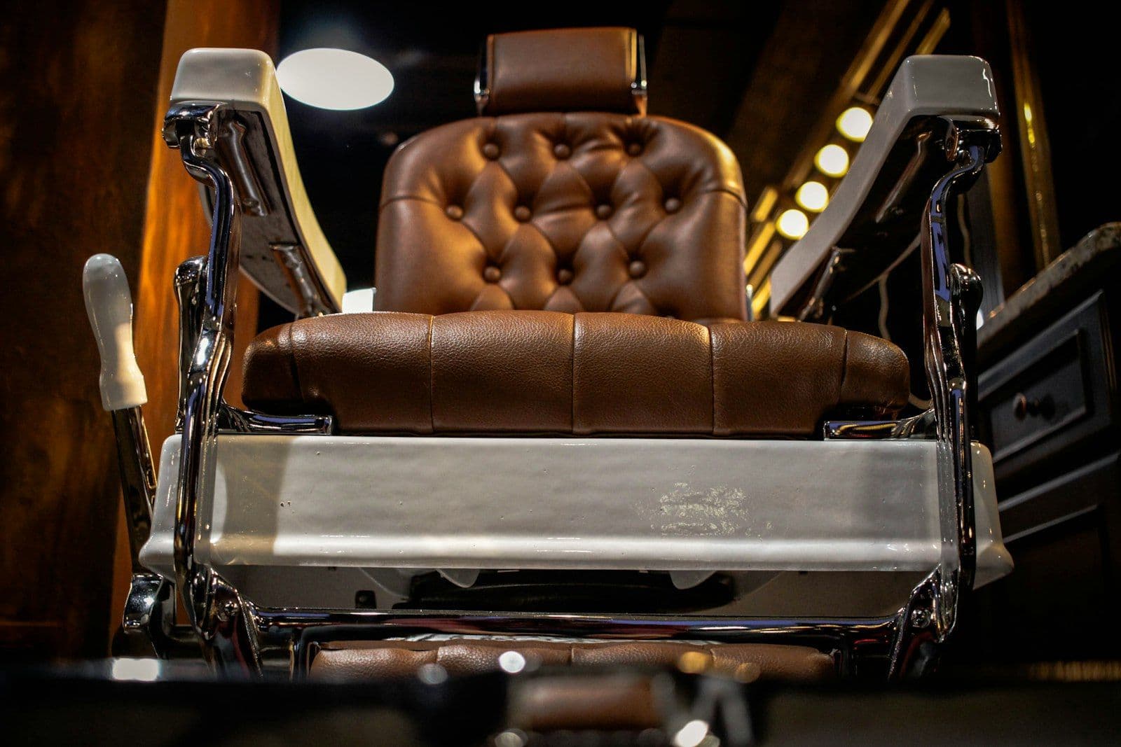 The gold-and-dark-green leather barber chair in Dani's polished-concrete private suite